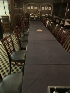 A view of a long dining table and dining chairs